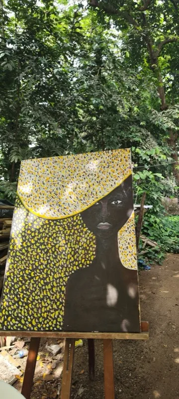 Portrait painting with yellow hat on easel outdoors