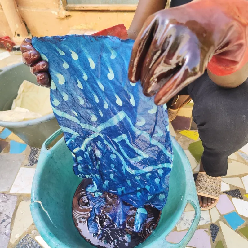 Revealing indigo-dyed shibori fabric from dye basin